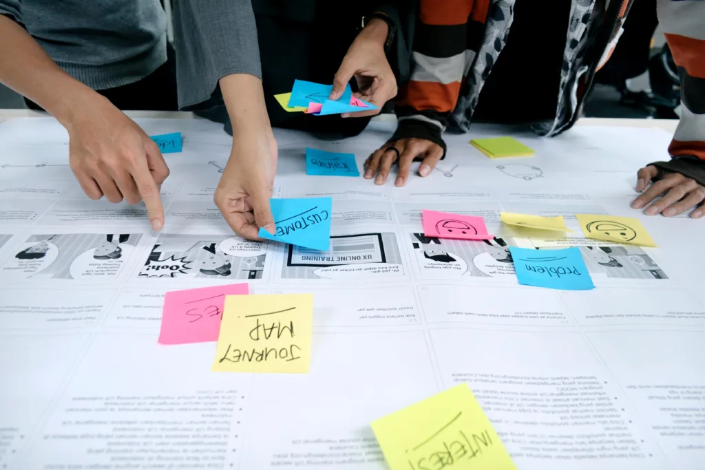 Multiple people working on a content layout with post it notes to depict content marketing and management