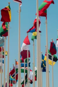 Various international flags on poles against a blue sky to indicate multilingual SEO and internationalism
