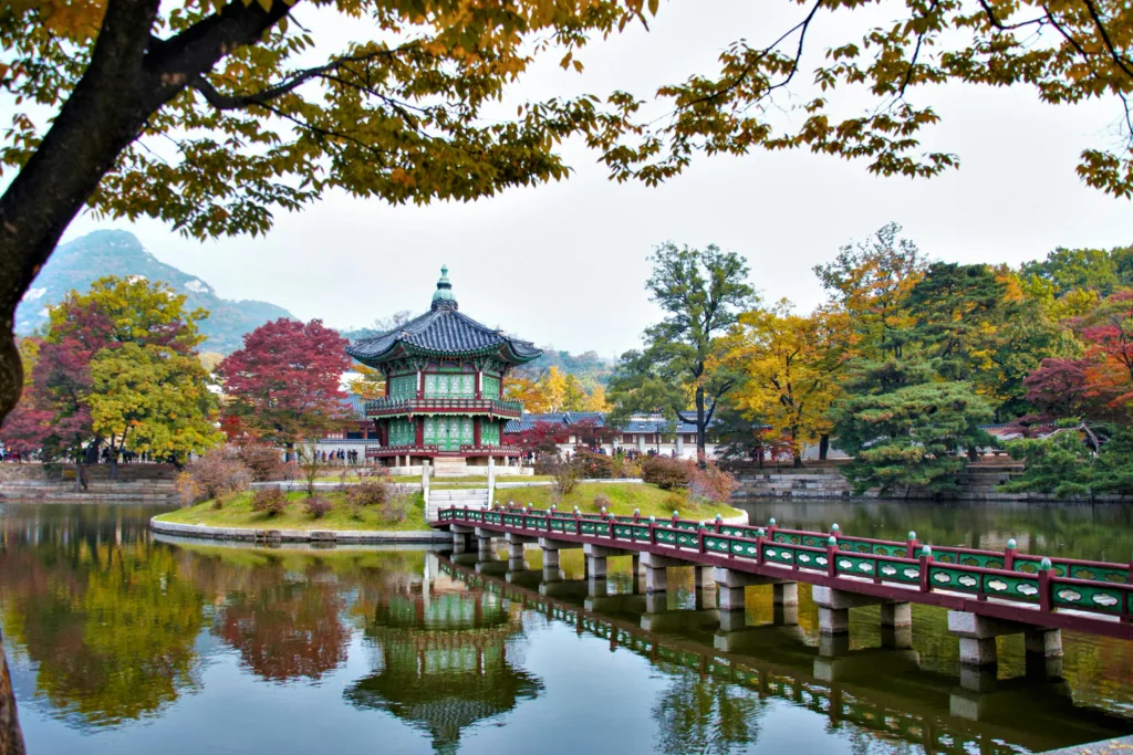 Gyeongbokgung Palace in the Middle of the Lake Surrounded with Autumn Trees Photo from Pexels