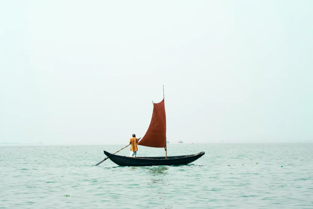 A Man Rowing A Small Boat With a Sail, Bangladesh